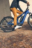 Mann fährt mit E-Bike um eine Hausecke.