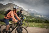 Zwei Personen im Gebirge auf Gravelbikes mit Taschen daran.