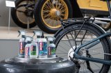 Mehrere Plastikflaschen mit Pflegemitteln vor einem Fahrrad.
