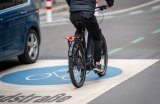 Eine Person fährt auf einem E-Bike über die Fahrbahnmarkierung einer Fahrradstraße.