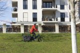 Frau fährt mit Cargobike in Stadt