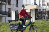 Frau steht mit Cargobike