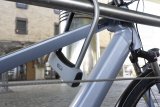 Ein Bügelschloss sichert ein Fahrrad mit dem Rahmen an einem Geländer.