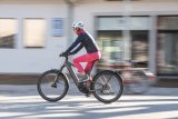 Eine Person fährt auf einem E-Bike durch die Innenstadt.